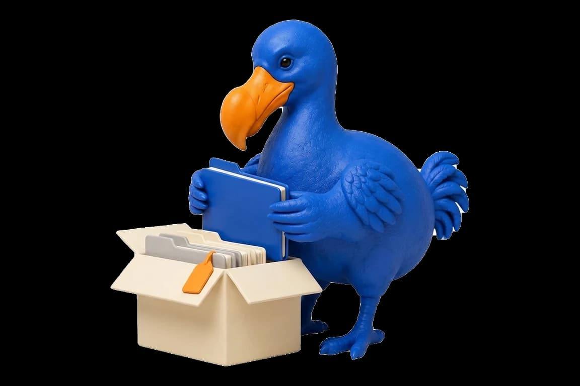 Le dodo bleu range une chemise cobalt dans un carton ivoire ouvert contenant déjà des dossiers et une étiquette de clé orange.